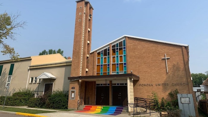 A church with a rainbow painted on its steps.