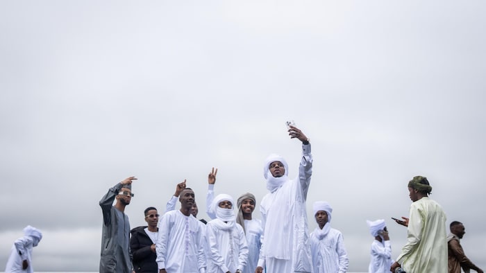 Un groupe pose pour un égoportrait devant une balustrade et du brouillard.