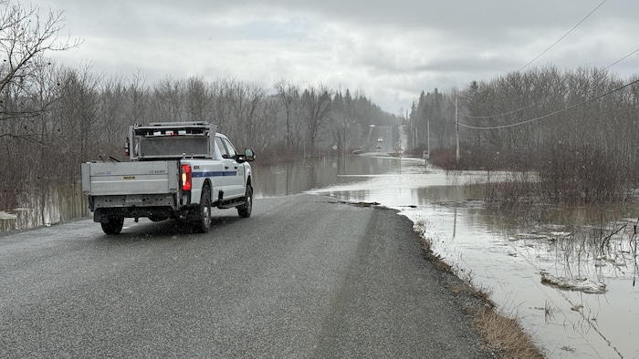 Un véhicule des travaux publics est stationné près du rang Lavigne, inondé.