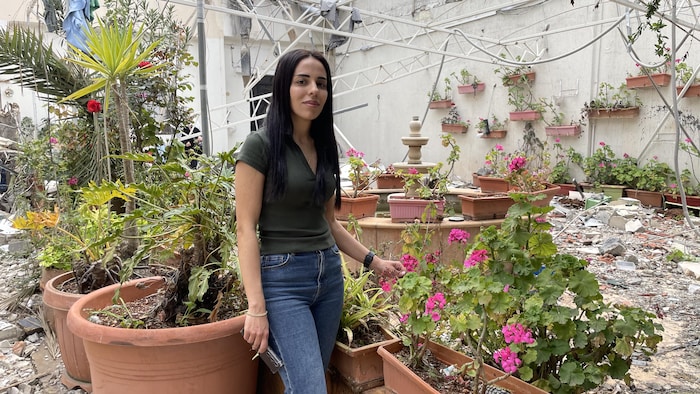 Ranine Ghandour pose dans son jardin devant sa maison détruite par la guerre à Nabatieh.