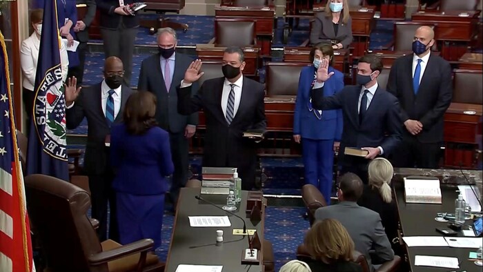 Les sénateurs Raphael Warnock (gauche), Jon Ossoff (centre) et Alex Padilla (droite) lèvent la main lors de leur prestation de serment devant la vice-présidente Kamala Harris.