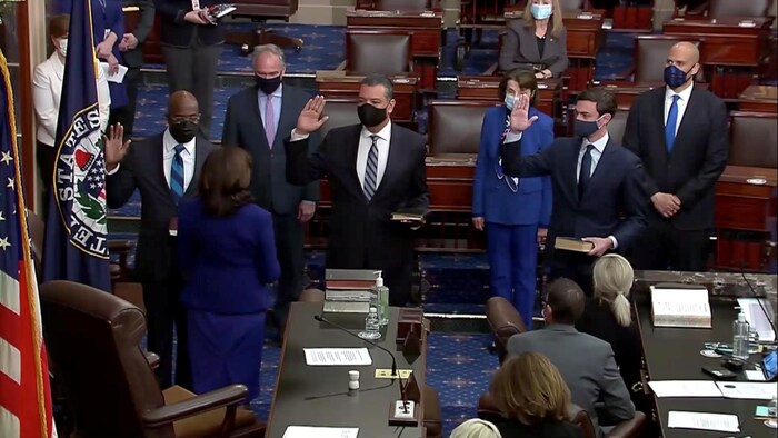 Les sénateurs Raphael Warnock (gauche), Jon Ossoff (centre) et Alex Padilla (droite) lèvent la main lors de leur prestation de serment devant la vice-présidente Kamala Harris. 