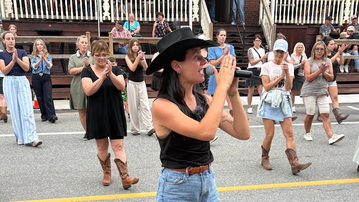 La professeure de danse en ligne country, Raphaëlle Côté-Germain, devant un groupe de danseurs.