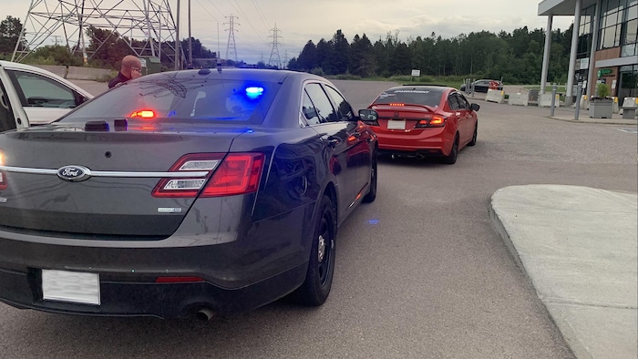 Un automobiliste arrêté dans le stationnement d'un commerce. 