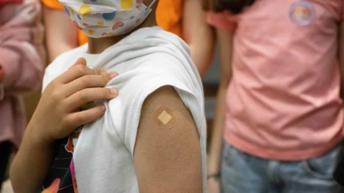 Un enfant lève sa manche pour montrer un pansement après avoir reçu un vaccin contre la COVID-19 à Vancouver, le lundi 29 novembre 2021.