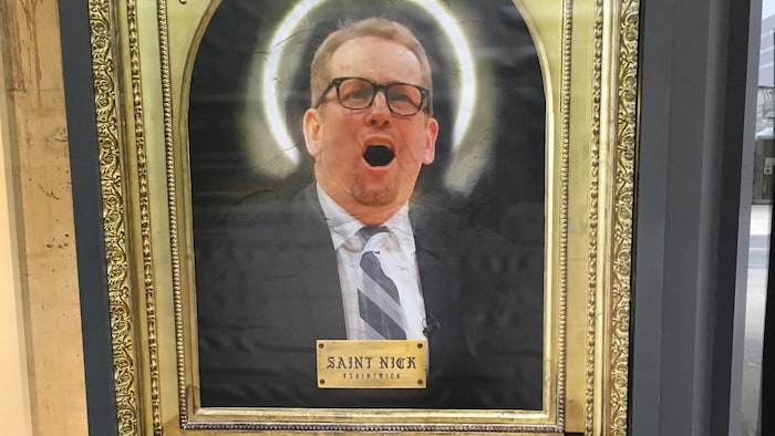 Photo d'une peinture de Nick Nurse dont la tête est entourée d'une auréole dans un cadre de couleur or.
