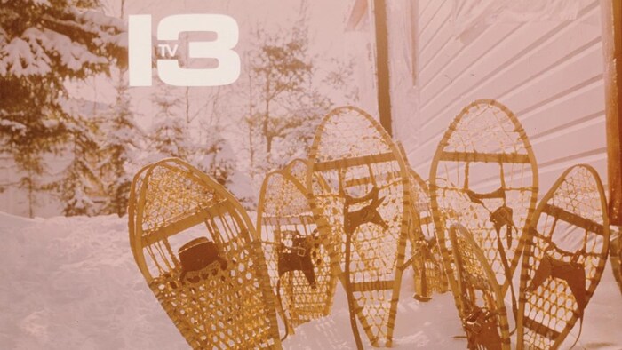Des raquettes sont plantées dans la neige sous l'inscription « 13 T V ».