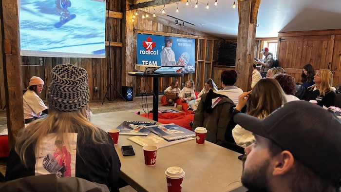 Une salle remplie de gens regardant une compétition de planche à neige