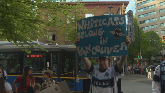 Un homme tient une pancarte qui affirme que la place des Whitecaps est à Vancouver.