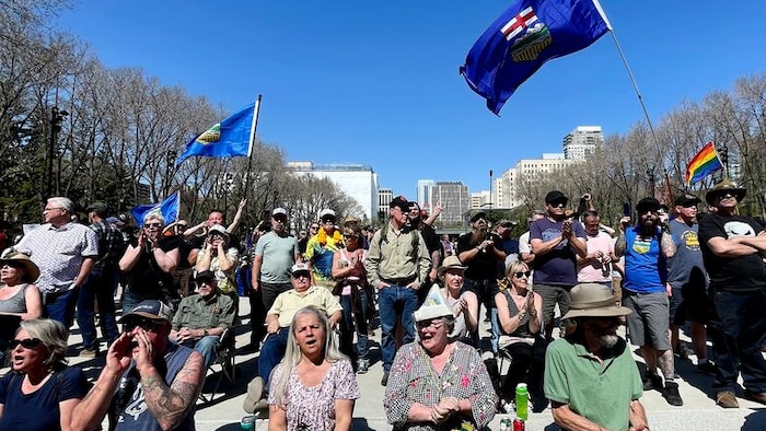Des personnes rassemblées sur l'esplanade de l'édifice de l'Assemblée législative.