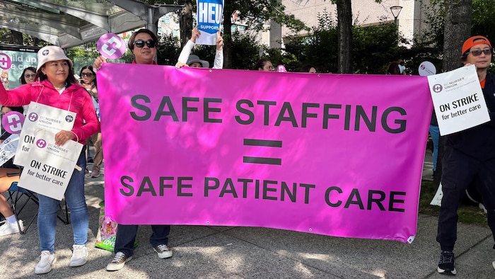 Une grande bannière rose avec le texte «Personnel en sécurité = Patients en sécurité», en anglais.