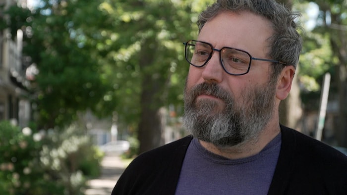 Raymond Poirier accorde une entrevue à l’extérieur, dans le quartier Limoilou, en été.