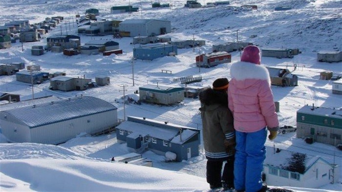 Deux enfants jettent un regard sur le village Quaqtaq, au Nunavik.
