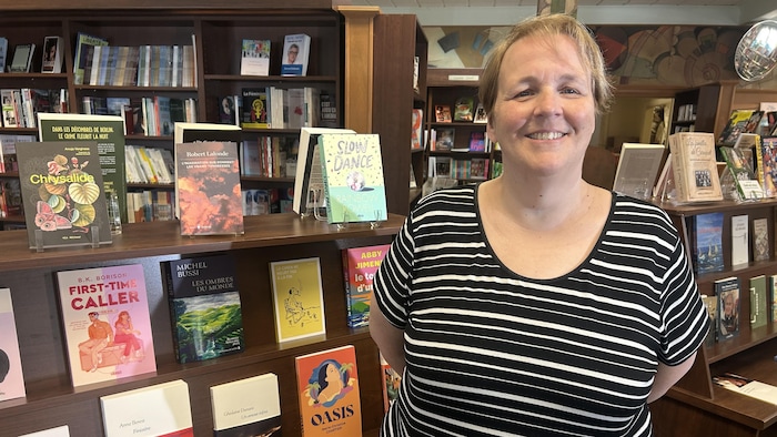 Lisette Cormier-Noël devant des étagères de livre.