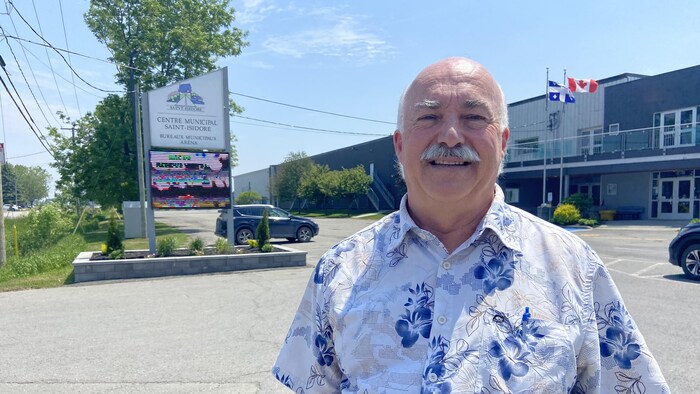 Portrait de Réal Turgeon avec, en arrière-plan, le Centre municipal Saint-Isidore. 