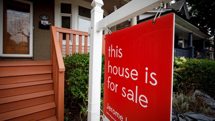 Un cartel delante de una casa que dice "Esta casa está en venta".