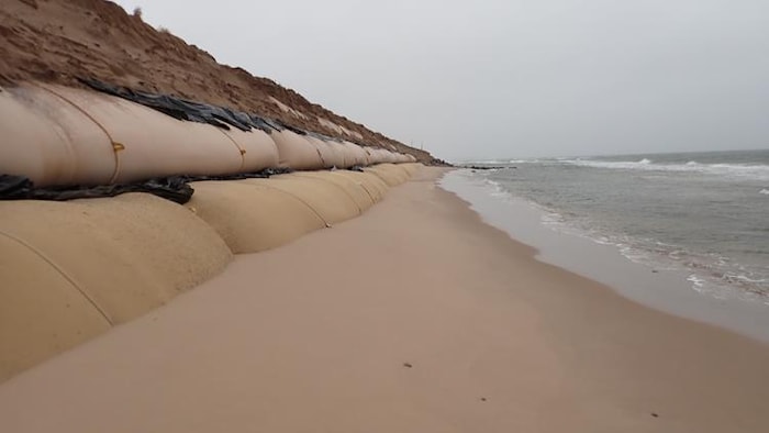 Des géotextiles à découverts devant une plage.