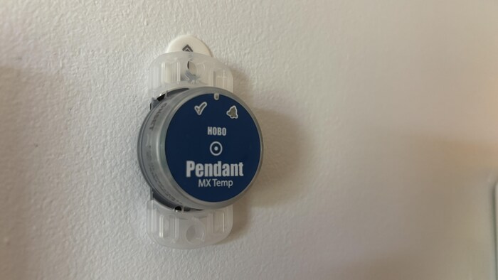 Un petit capteur collé à un mur.