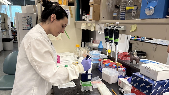 Une femme en sarrau dans un laboratoire.