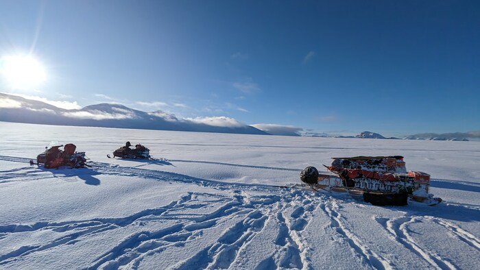 Deux motoneiges dans l'Arctique canadien.