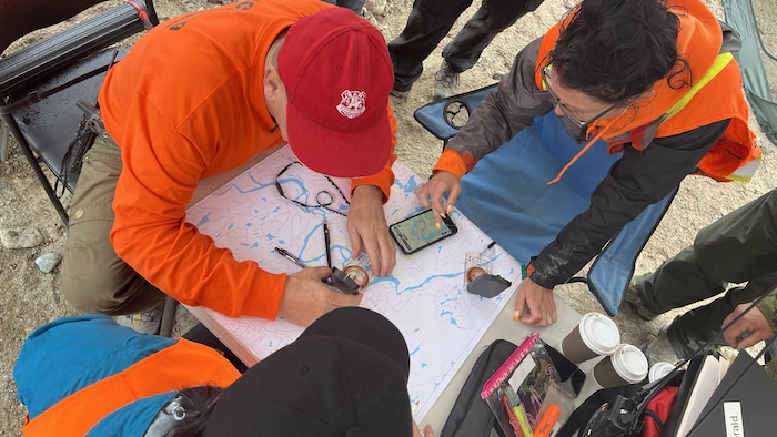Des gens regardent une carte sur une table.