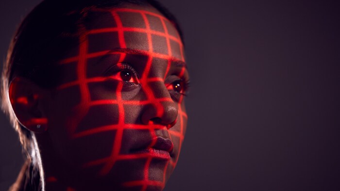 Le visage d'une femme encadré de lasers.