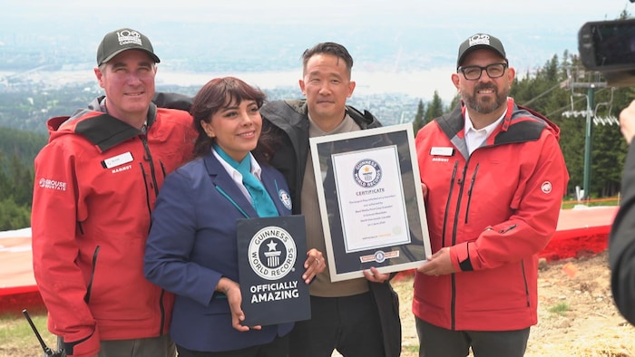 Un groupe pose avec l'attestation d'un record du monde. 