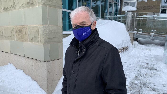 Un homme devant un établissement, à l'extérieur.