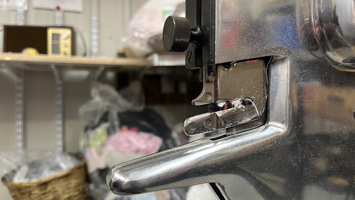Plan rapproché d'une machine en métal où des petits résidus de tissus sont accrochés.