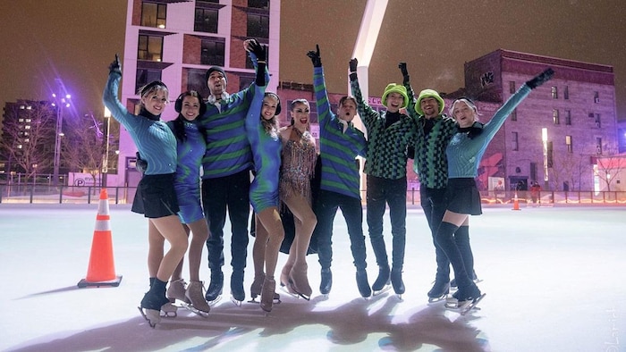 Des patineurs et des patineuses posent sur la glace. 