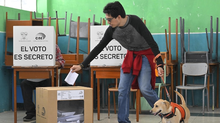 A man casts his vote accompanied by his dog at a polling station during a referendum on tougher measures against organized crime in Quito on April 21, 2024. Ecuadorans voted Sunday in a referendum on proposed tougher measures to fight gang-related crime. The once-peaceful South American country has been grappling with a shocking rise in violence that has seen two mayors killed this week. (Photo by Rodrigo BUENDIA / AFP) (Photo by RODRIGO BUENDIA/AFP via Getty Images)