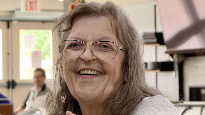 Une femme âgée sourit.