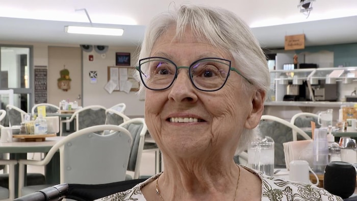 Une femme âgée sourit.