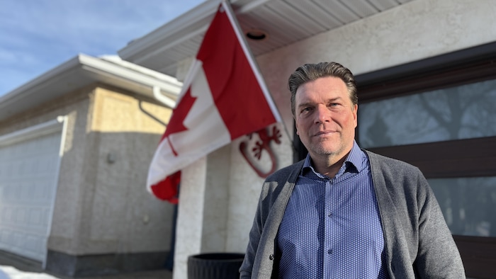 Thomas Lukaszuk est dehors devant un drapeau canadien en Alberta en janvier 2026.