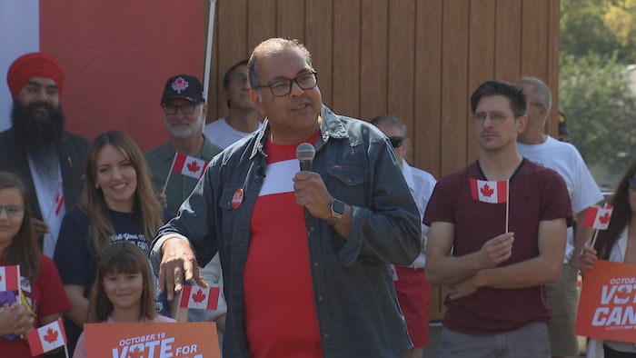 Naheed Nenshi avec des militants tenant des drapeaux canadiens.