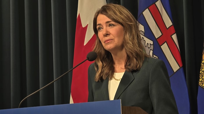 Danielle Smith parle devant un micro.