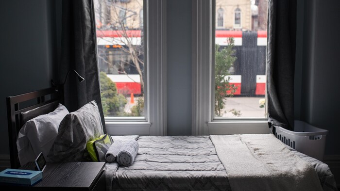 Une chambre dans un refuge avec une vue de la rue et d'un tramway.