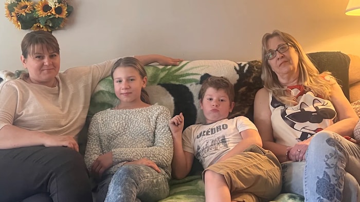 Quatre personnes assises sur un divan.