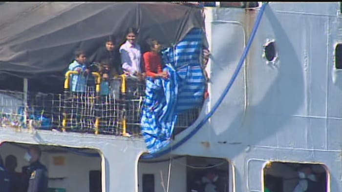 Des adultes et des enfants sont appuyés au bastingage du MV Sun Sea.