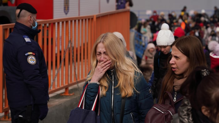 لاجئون أوكرانيون وصلوا إلى رومانيا وبينهم امرأة تجهش في البكاء. 