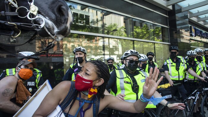 Des manifestants s'écartent en vitesse quand un policier à cheval se fraie un passage dans la foule à la marche anniversaire du 24 mai.