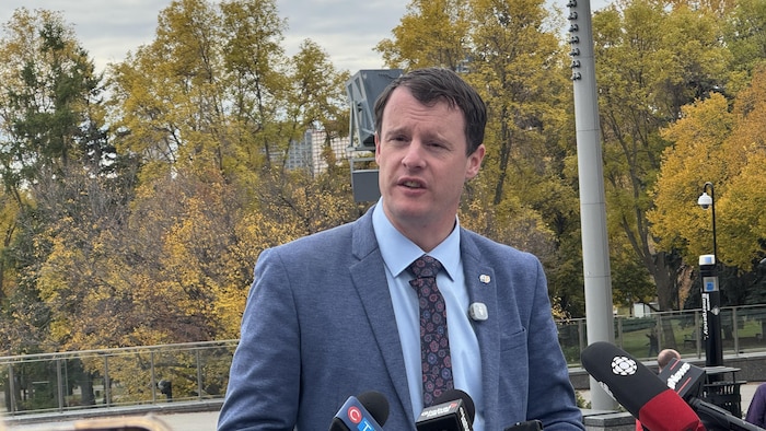 Dylan Brassey devant un lutrin lors d'une conférence de presse à l'extérieur.