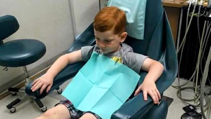 Le fils d’Heather Harrington, Reid, âgé de 6 ans, est assis dans la salle de soins du cabinet dentaire du Dr Chan.