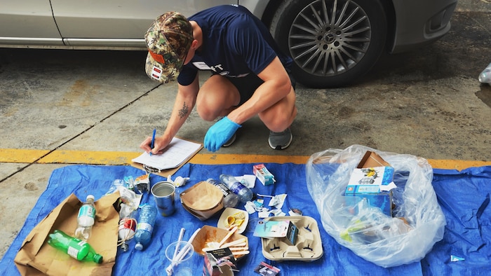 Rein Maynard examine des déchets au sol.