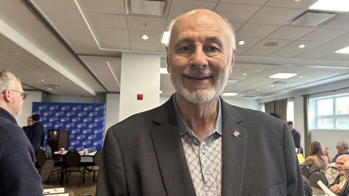 Réjean Savoie, souriant dans une salle de conférence.