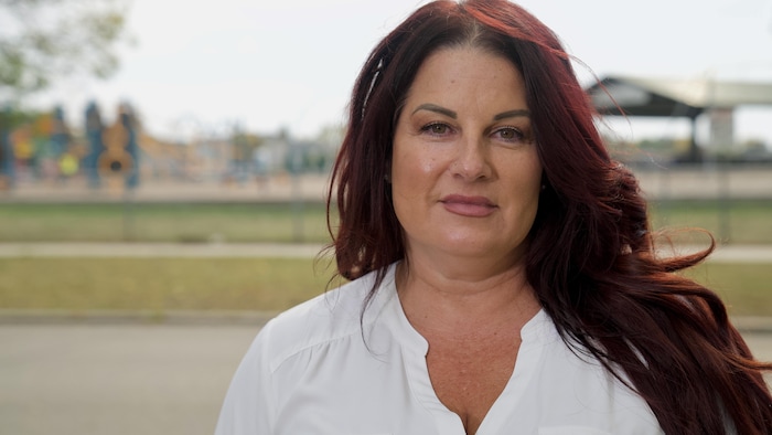 Reéjeanne Caron devant un parc pour enfants.