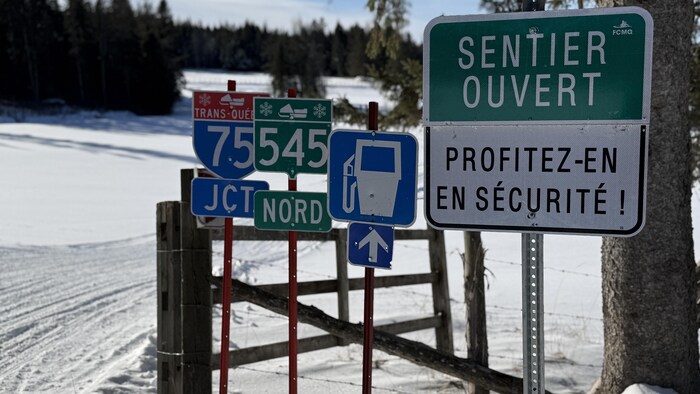 Des pancartes indiquant les sentiers et services pour motoneigistes.
