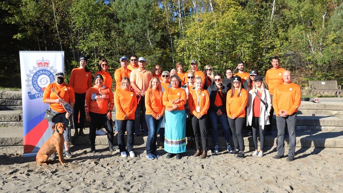 Des gens vêtu d'un chandail orange posent pour une photo de groupe.