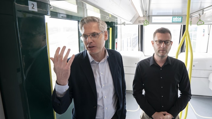 Julien Hurel et Carl Corbel debout dans le train léger.