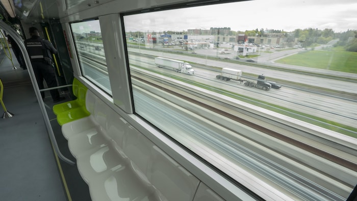 Le train léger, surélevé, longe l'autoroute 40.